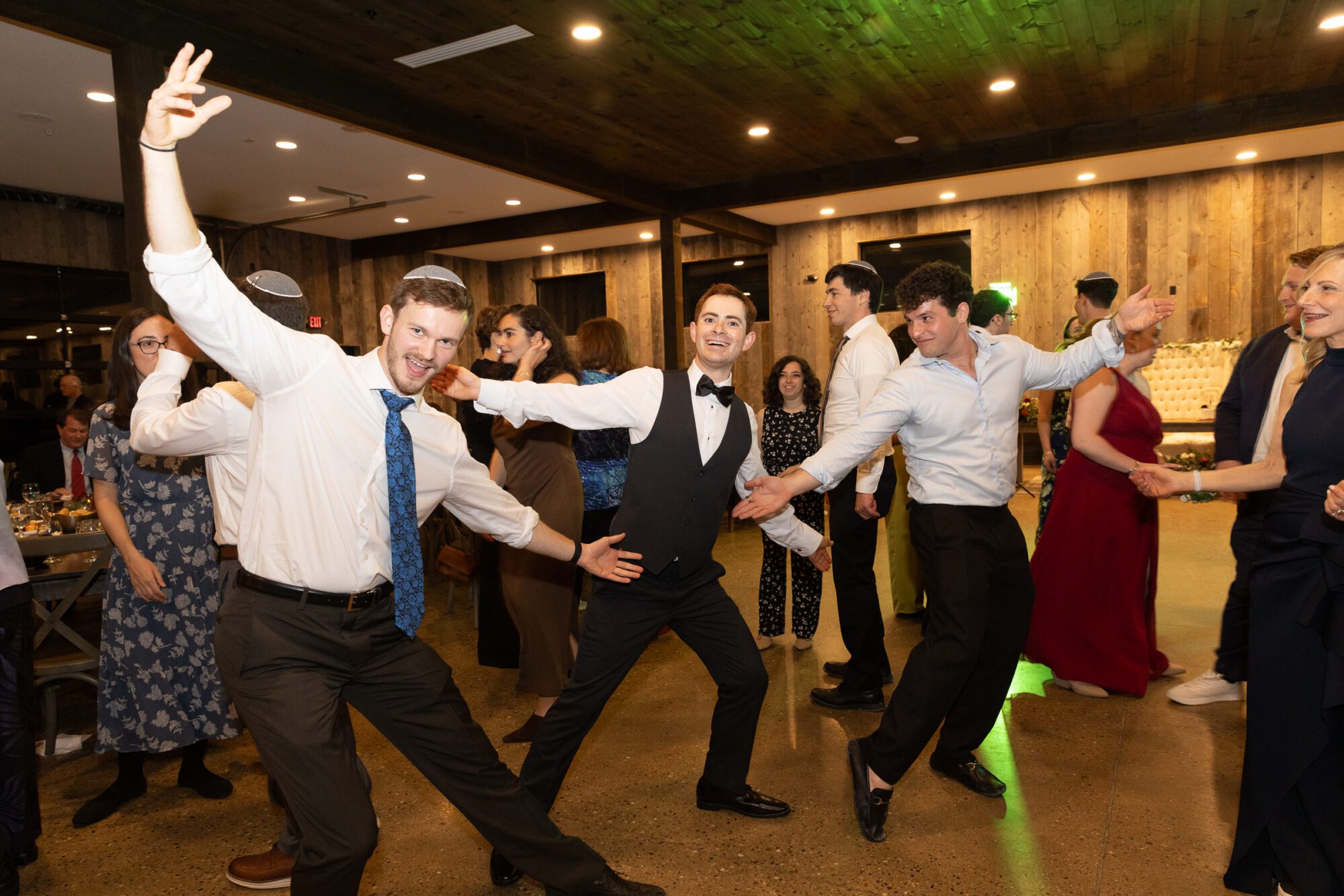 Jewish Groom dances with friends at wedding reception.