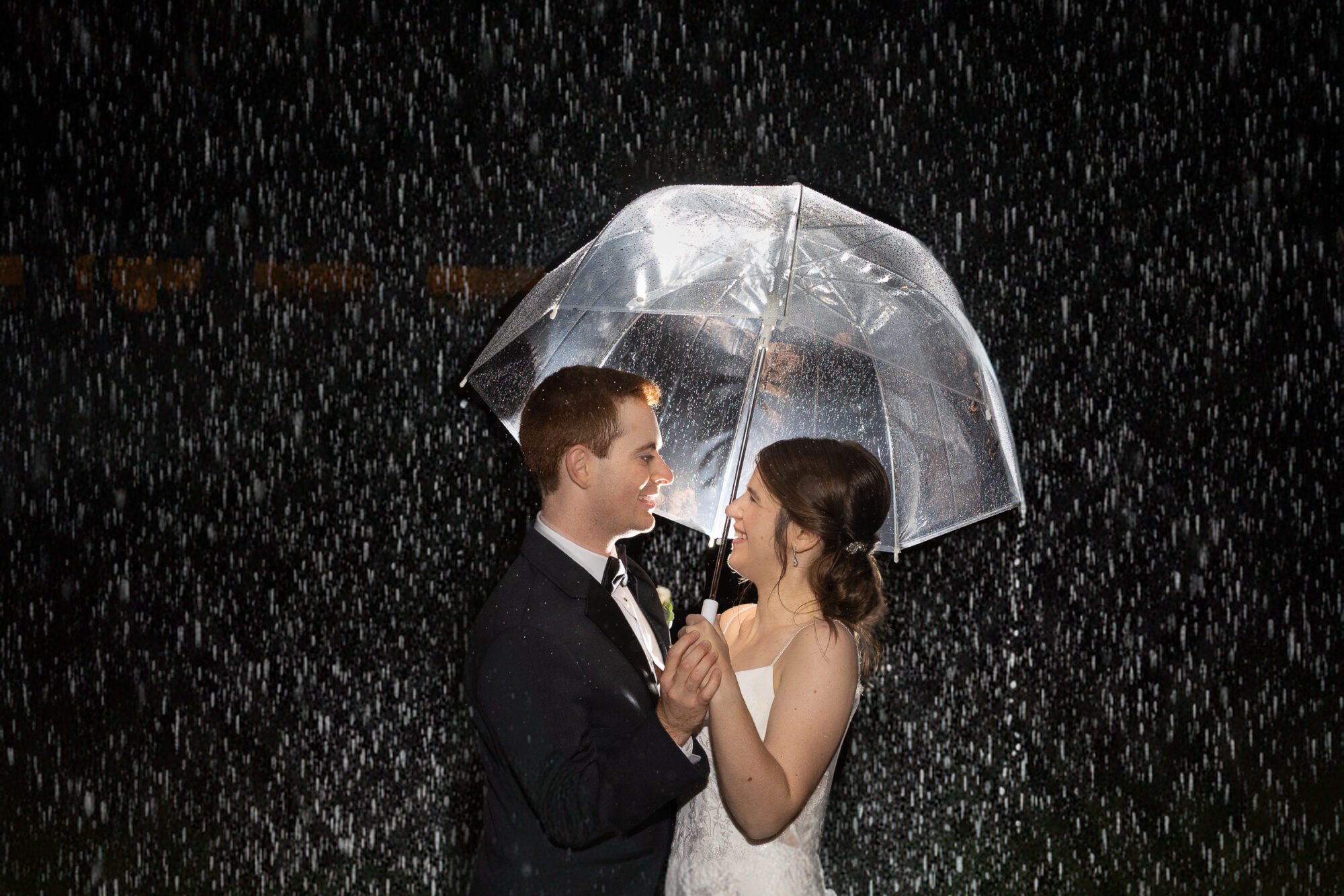 Jewish Bride and Groom under umbrella in the rain on their wedding day.