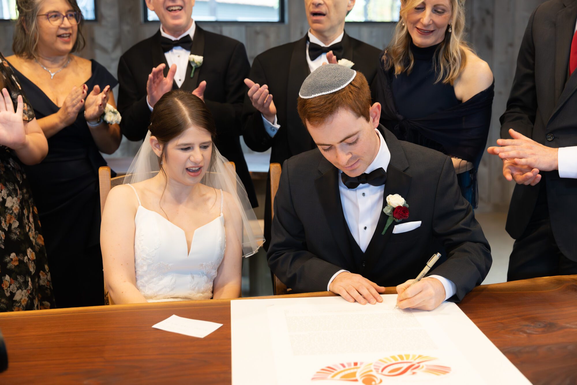 Jewish bride and groom's wedding ketubah signing ceremony. Groom signs ketubah.