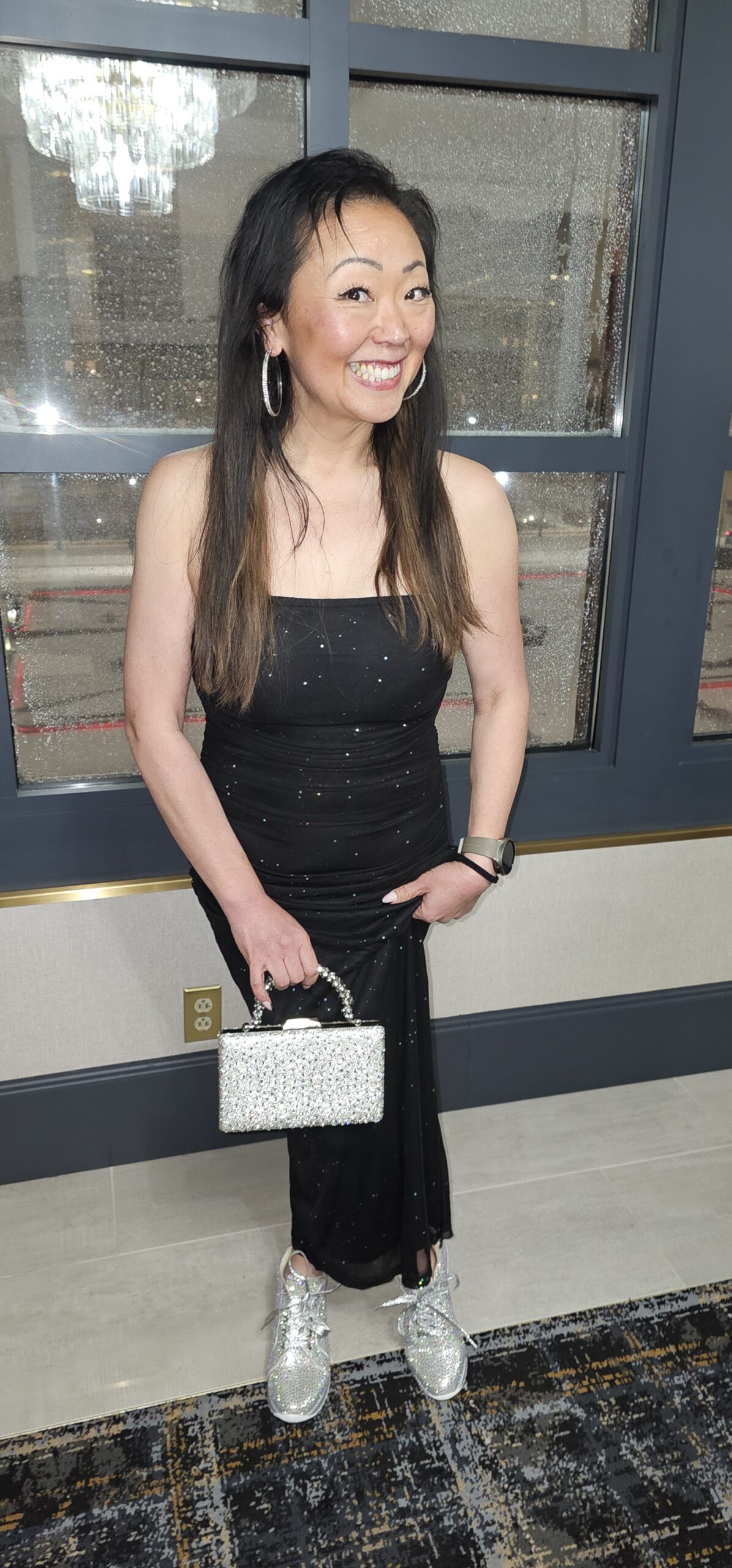 Lana Perhacs, Certified Professional Photographer, wearing a black formal dress and sparkly silver accessories at an evening event.