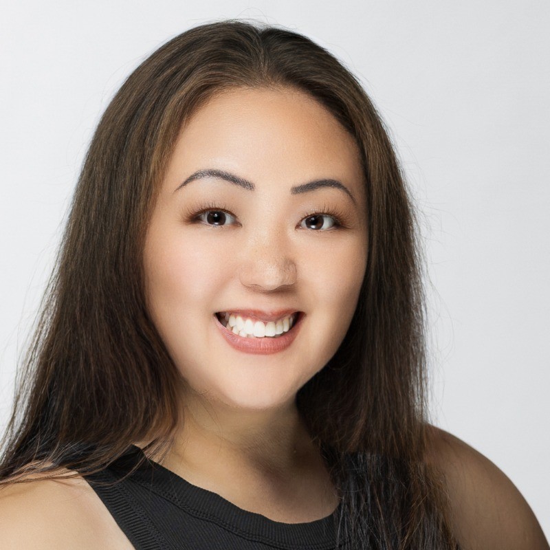 Lana Perhacs, Owner and Photographer at Mystic Image, smiling in a high-key studio portrait.