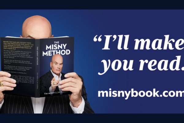Tim Misny holding open his book The Misny Method with a quote that reads I'll make you read next to the website URL misnybook.com